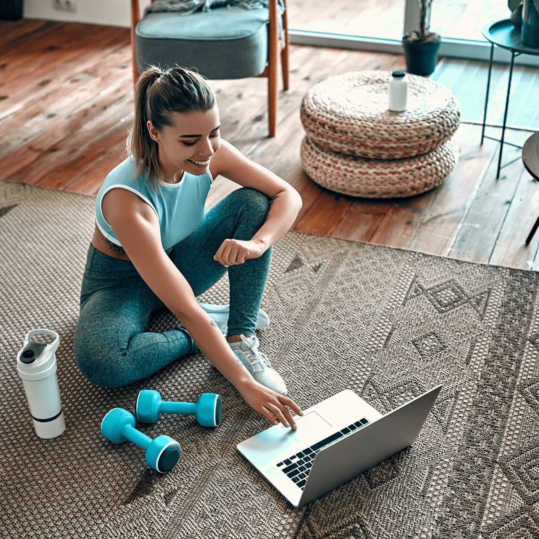 Woman working out with her lap top to practice wellness